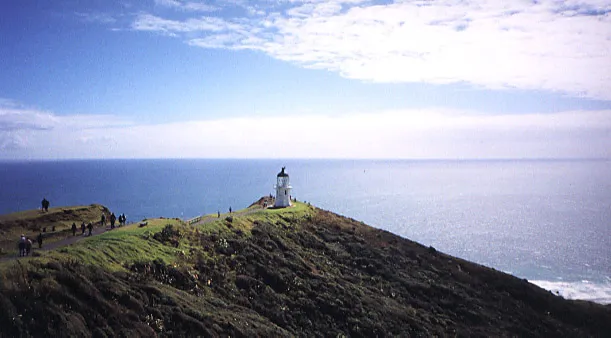 Lighthouse on a hill overlooking the ocean and sea.