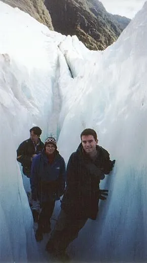 Man in warm clothes walking inside a glacier.