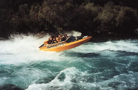 Yellow speedboat mid-air through white rapids.